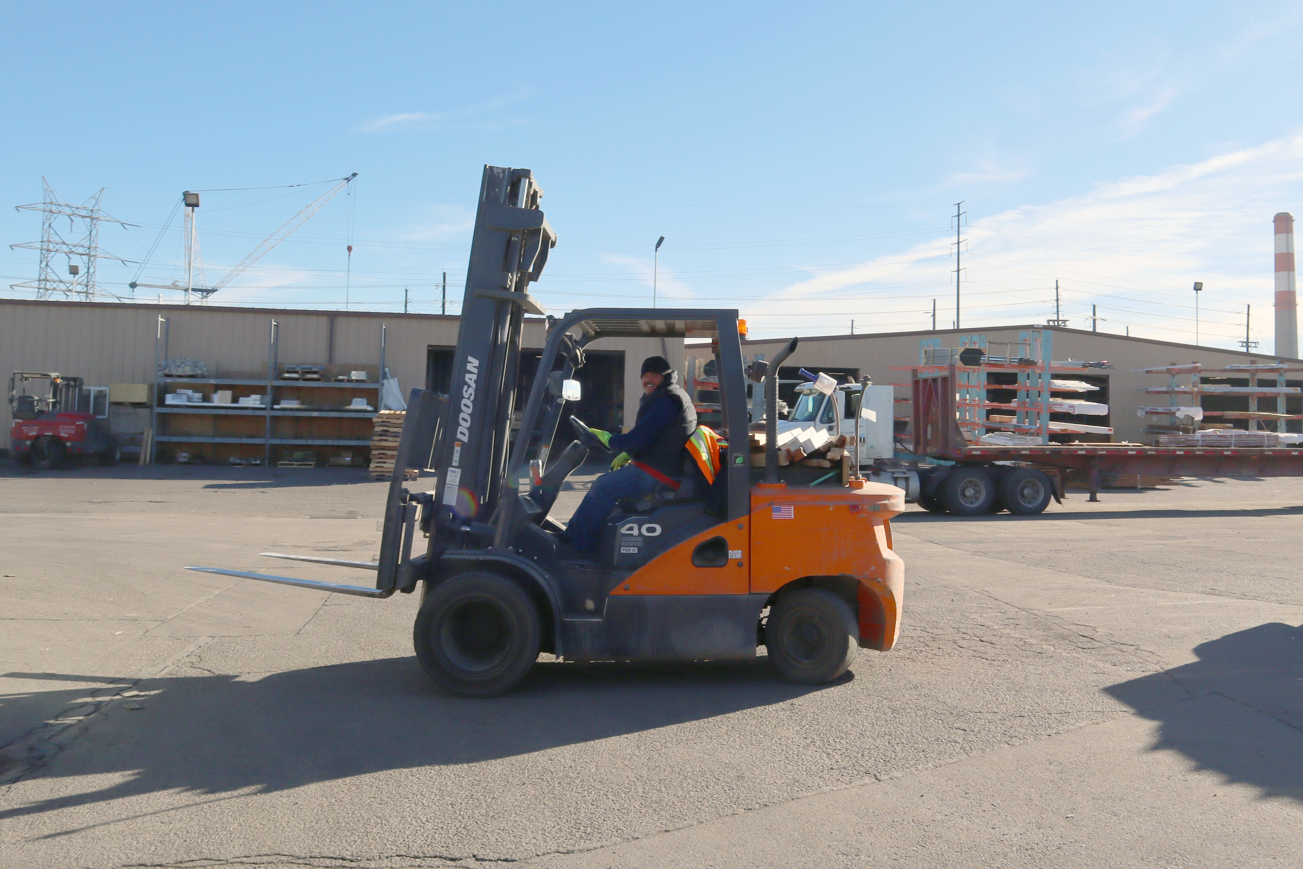 Forklift and forklift operator in the yard at Direct Lumber and Door of Colorado